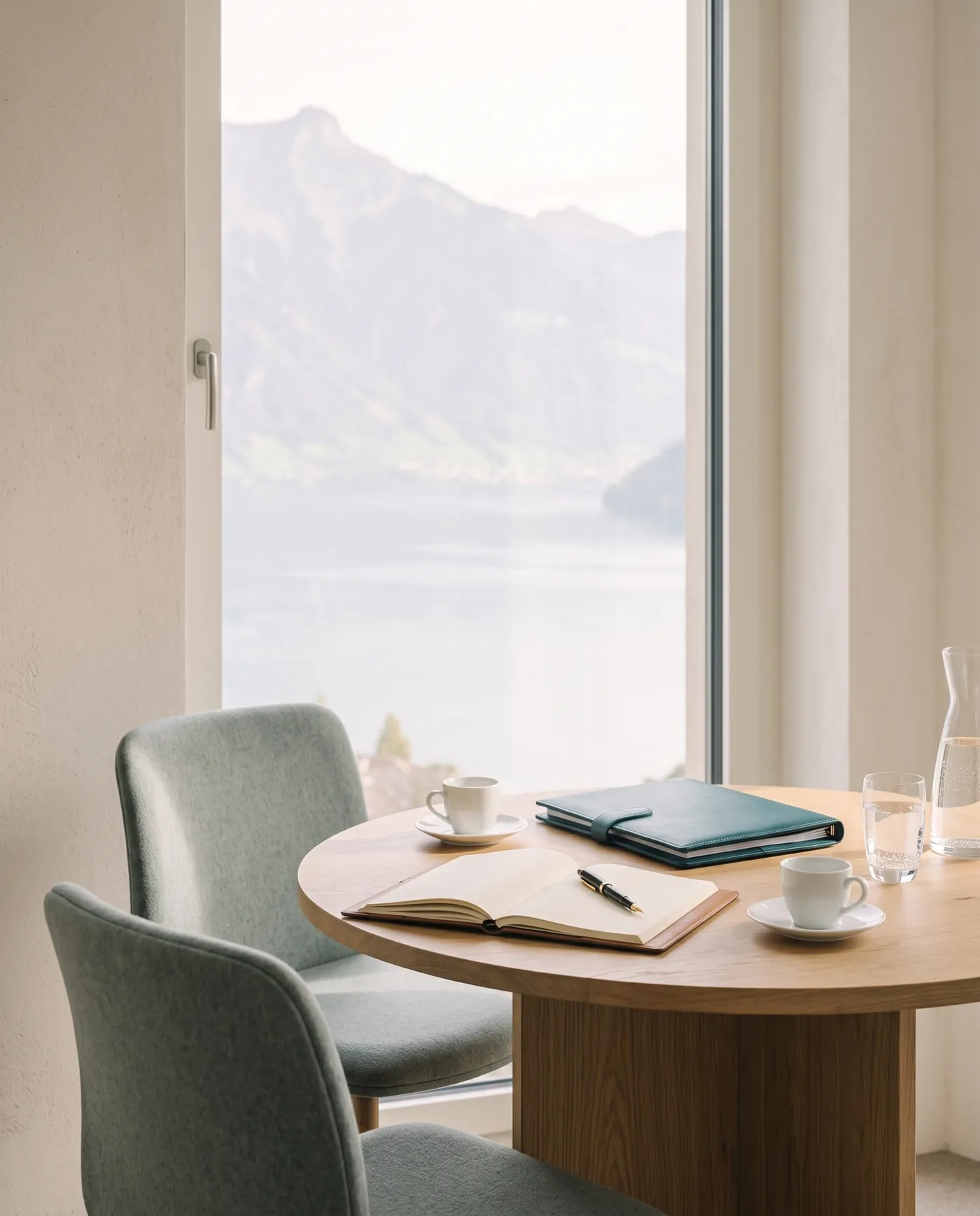Runder Tisch am Fenster mit zwei Kaffeetassen und Notizbuch, vorbereitet für ein Erstgespräch